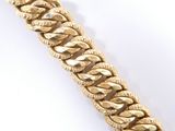 a close up of a gold chain bracelet on a white background
