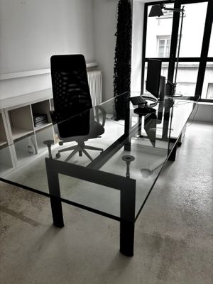 un bureau en verre avec une chaise au milieu