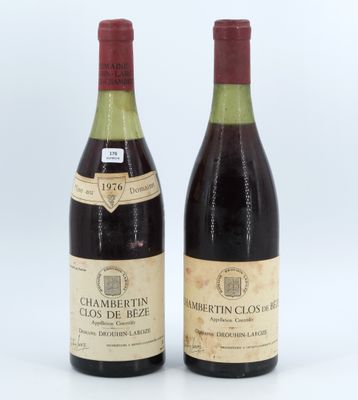 two bottles of wine sitting next to each other on a white surface