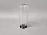 a clear glass vase with a black base on a white background