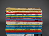 many books stacked on top of each other on a table