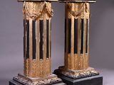 pair of black and gold pedestals on a gray background