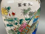 a vase that has a bird and flowers on it