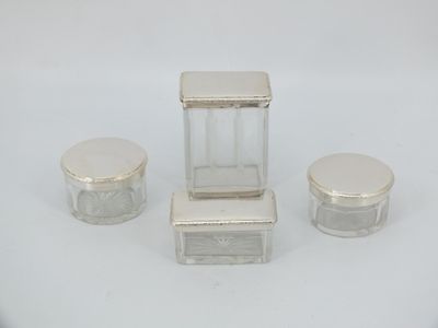 three small glass jars with lids and lids on a white surface