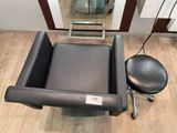 une chaise noire et un tabouret noir dans une pièce