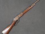 a rifle with a wooden handle on a gray surface