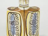 a small bottle with a design on it on a white surface
