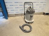 a vacuum is sitting on the floor in front of a wall