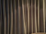 curtains in a living room with a chair and a lamp
