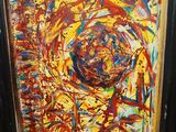 framed painting of a colorful abstract painting in a black frame