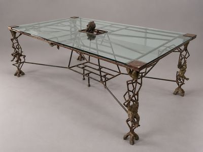 une photo d'une table en verre avec un piètement métallique et un plateau en verre