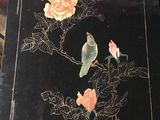 a black table with a bird and flowers on it