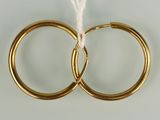 pair of gold hoop earrings with white thread on white background