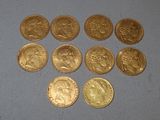 six types différents de pièces d'or posées sur une surface bleue