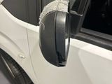 a small white car with a mirror on the side of it