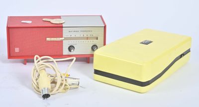 une radio jaune et rouge et un chargeur posés sur une surface blanche