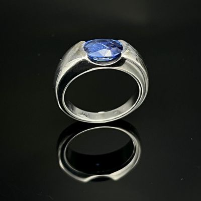 une image représentant une bague ornée d'une pierre bleue sur un fond noir