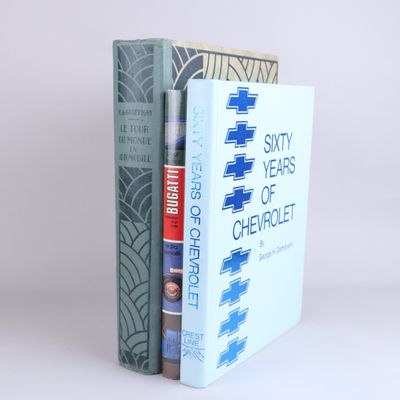 two books are stacked on top of each other on a white surface