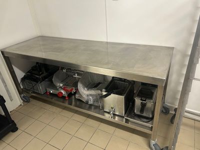 une table en acier inoxydable sur laquelle sont posés tout un tas d'objets