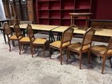 Des tables et des chaises sont alignées dans une pièce aux murs rouges.