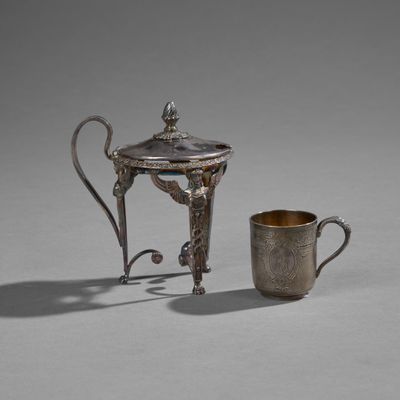 silver plated teapot and cup on a table with grey background