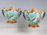 pair of vases with birds and flowers painted on them sitting on a table