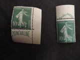 two stamps of different sizes and colors are on a black surface