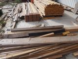 a pile of wood sitting on the ground next to a building