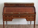 an antique writing desk with two drawers and gold trimmings