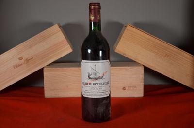 a bottle of wine sitting on a table next to two wooden boxes