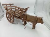 a wooden horse pulling a wooden cart on a white surface