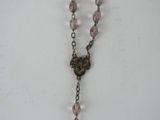 rosary necklace with pink glass beads and a bronze cross