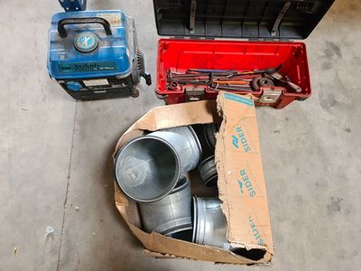 une boîte contenant tout un tas d'objets, posée par terre