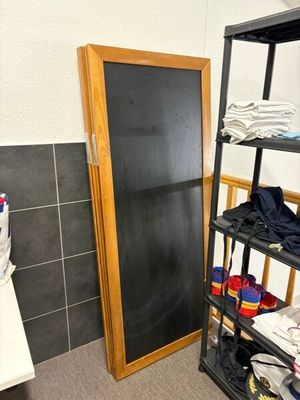 a bathroom with a toilet and a shelf with clothes