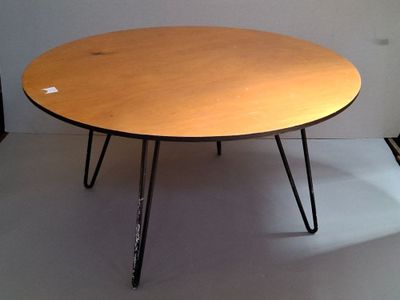 a wooden table with black hairpin legs on a white floor