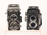 two old cameras that are on display on a table