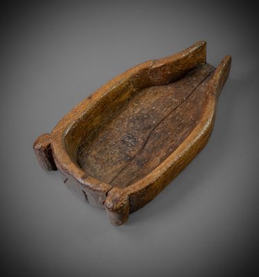 an old wooden boat with a wooden handle on a gray surface