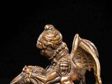 an antique bronze statue of a boy on a dragon