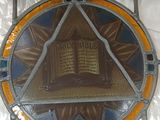 a stained glass window with a picture of a book on it