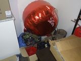 un gros ballon rouge posé au sommet d'une pile de cartons