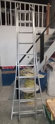 une photo d'une échelle dans un garage, avec une autre échelle à côté