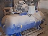 un gros compresseur d'air posé sur une palette dans un garage