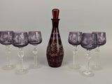 four wine glasses and a wine decanter on the table