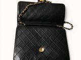 a black purse with a gold chain hanging from it