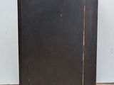 an old black cabinet with a wooden top on a tiled floor