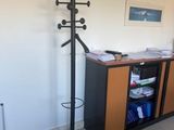 une photo d'une pièce avec un bureau et un porte-manteau
