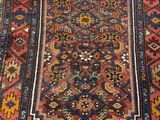 a close up of a rug on a wooden floor next to a wall