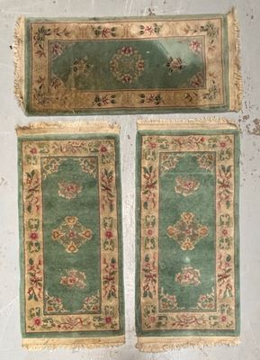 trois morceaux de tapis verts posés sur une surface blanche