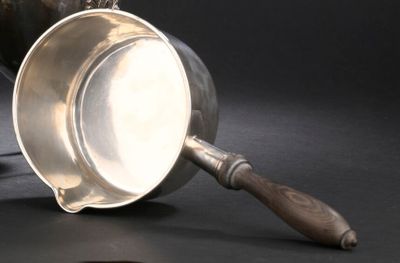 une coupe en argent avec un manche en bois sur un fond noir