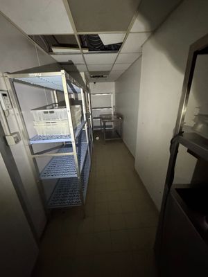 un long couloir dans un bâtiment où se trouvent de nombreuses étagères